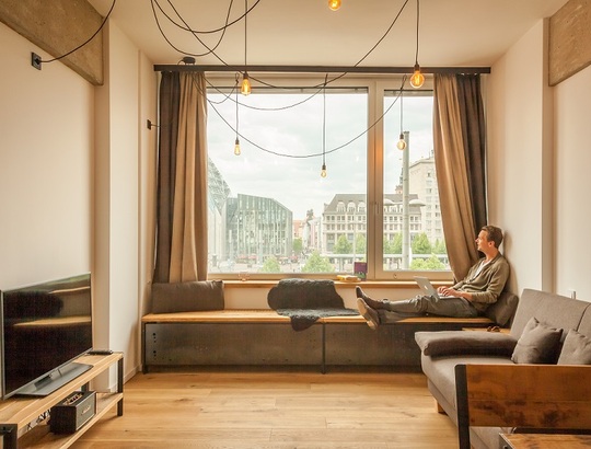 Einblick in ein Wohnzimmer mit gemütlicher Fensterplatz Sitzmöglichkeit in den Felix Suiten 