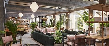 Einblick in den modernen Aufenthaltsraum mit vielen Pflanzen des Apartmenthauses "Wunderlocke", welches Anfang 2021 in München eröffnen soll